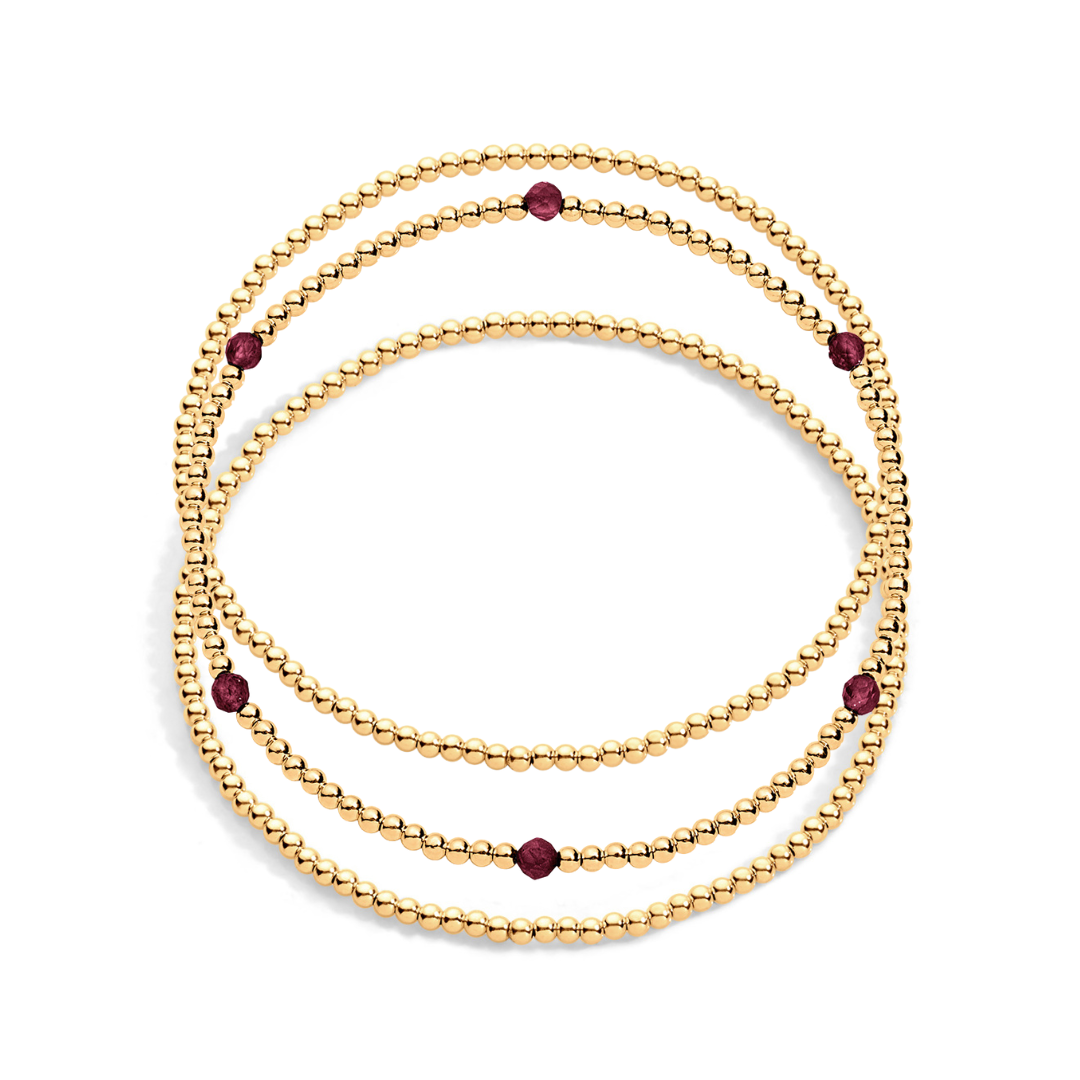 3 gold filled beaded bracelets with one having garnet gemstones