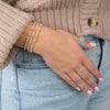 model wearing various mixed metals bracelets and rings