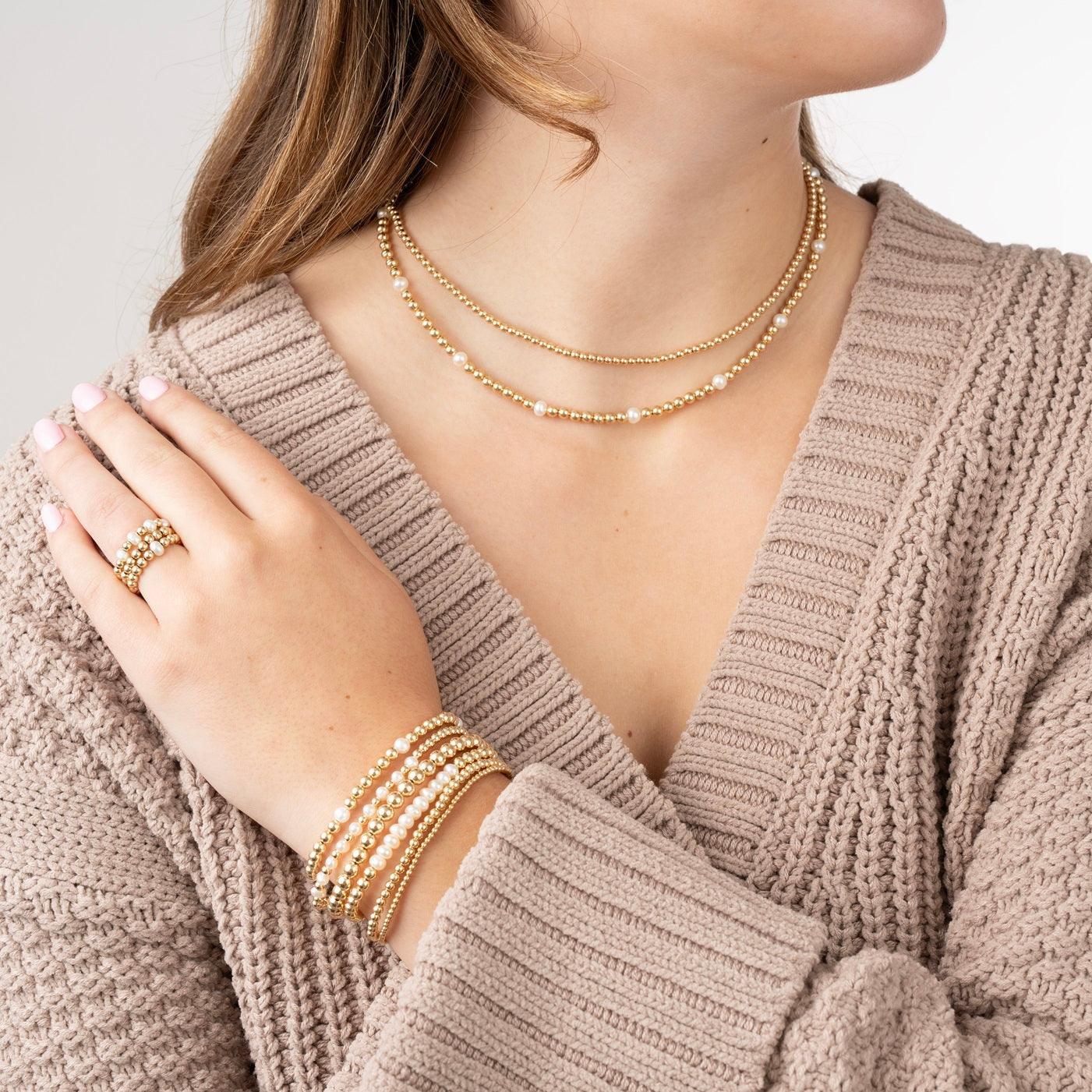 model wearing gold-filled beaded bracelets and necklaces some with pearls