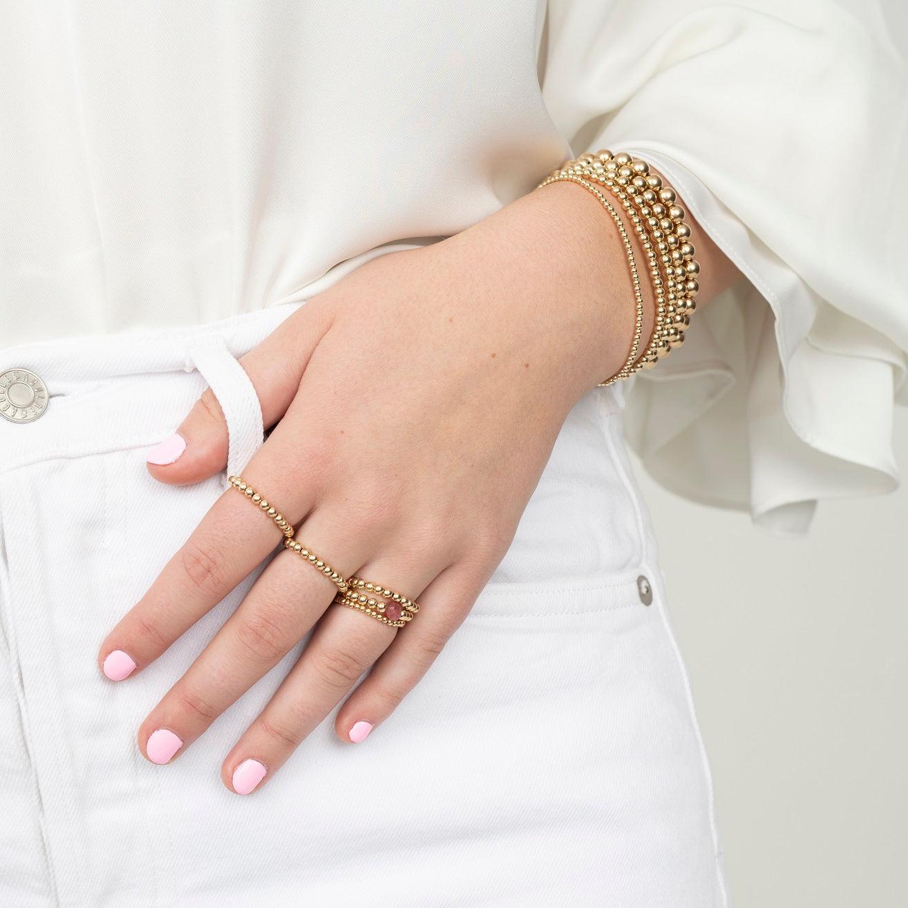 model wearing gold filled beaded rings and bracelets